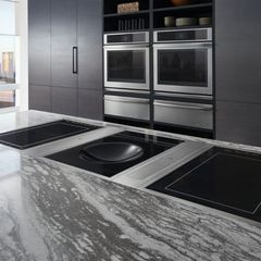 A kitchen with stainless steel appliances and a marble counter top