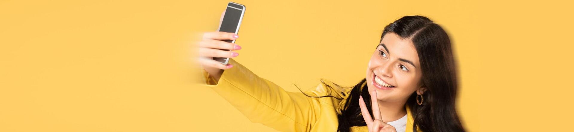 A woman is taking a selfie with her cell phone.
