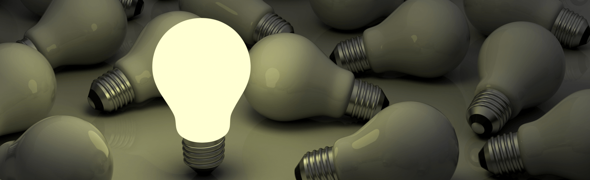 A group of light bulbs with one glowing brightly