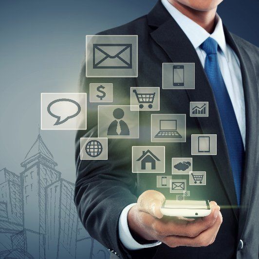 A man in a suit and tie is holding a cell phone with icons coming out of it