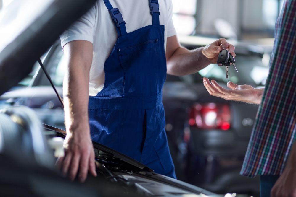 meccanico mentre riconsegna l'auto al cliente