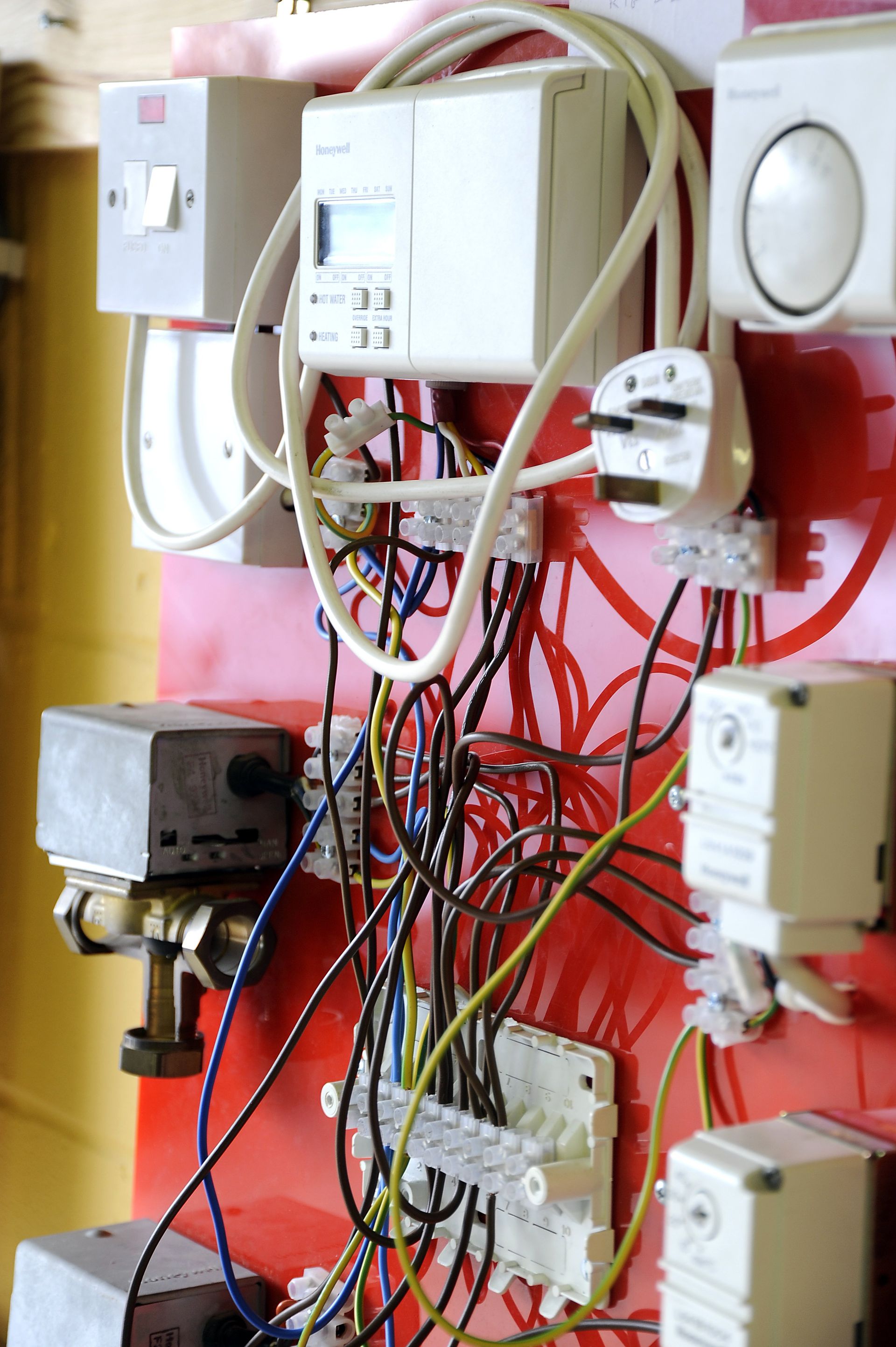 A bunch of wires are hanging on a red wall
