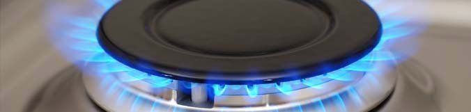 A close up of a gas burner with blue flames coming out of it.