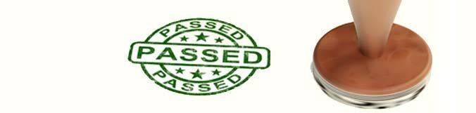 A close up of a stamp that says passed on a white background.