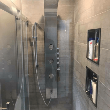 Une douche avec une porte coulissante en verre et une pomme de douche