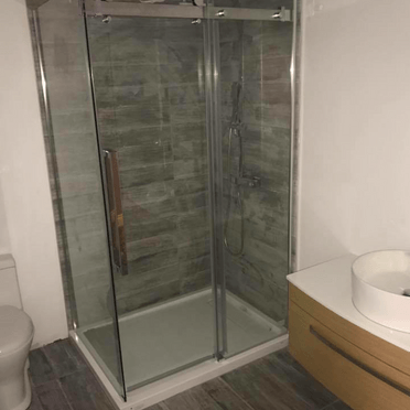 Une salle de bain avec WC, lavabo et cabine de douche.