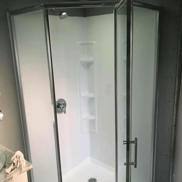 Une cabine de douche avec une porte vitrée dans une salle de bain.