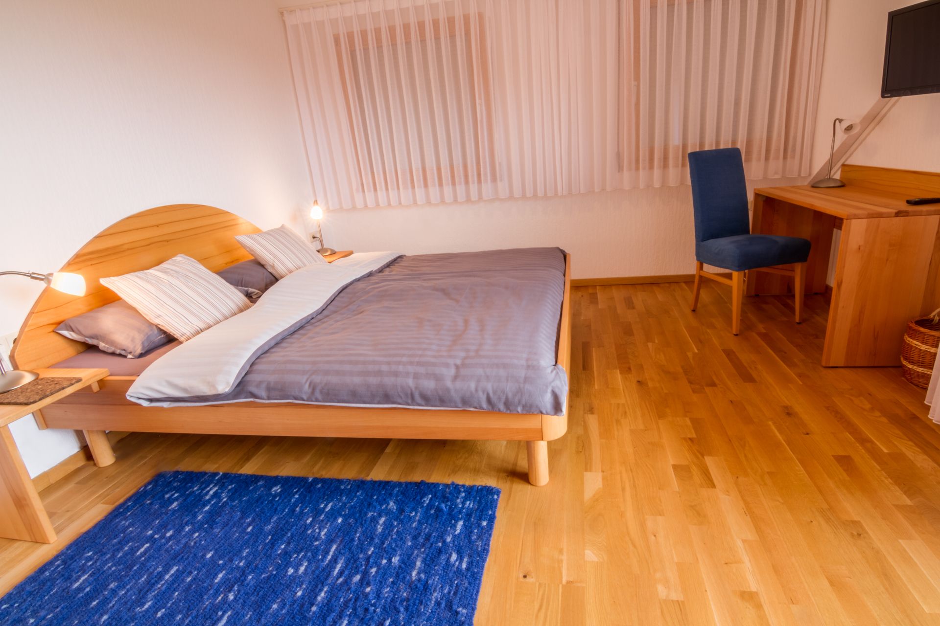 Ein Schlafzimmer mit einem großen Bett und einem blauen Teppich