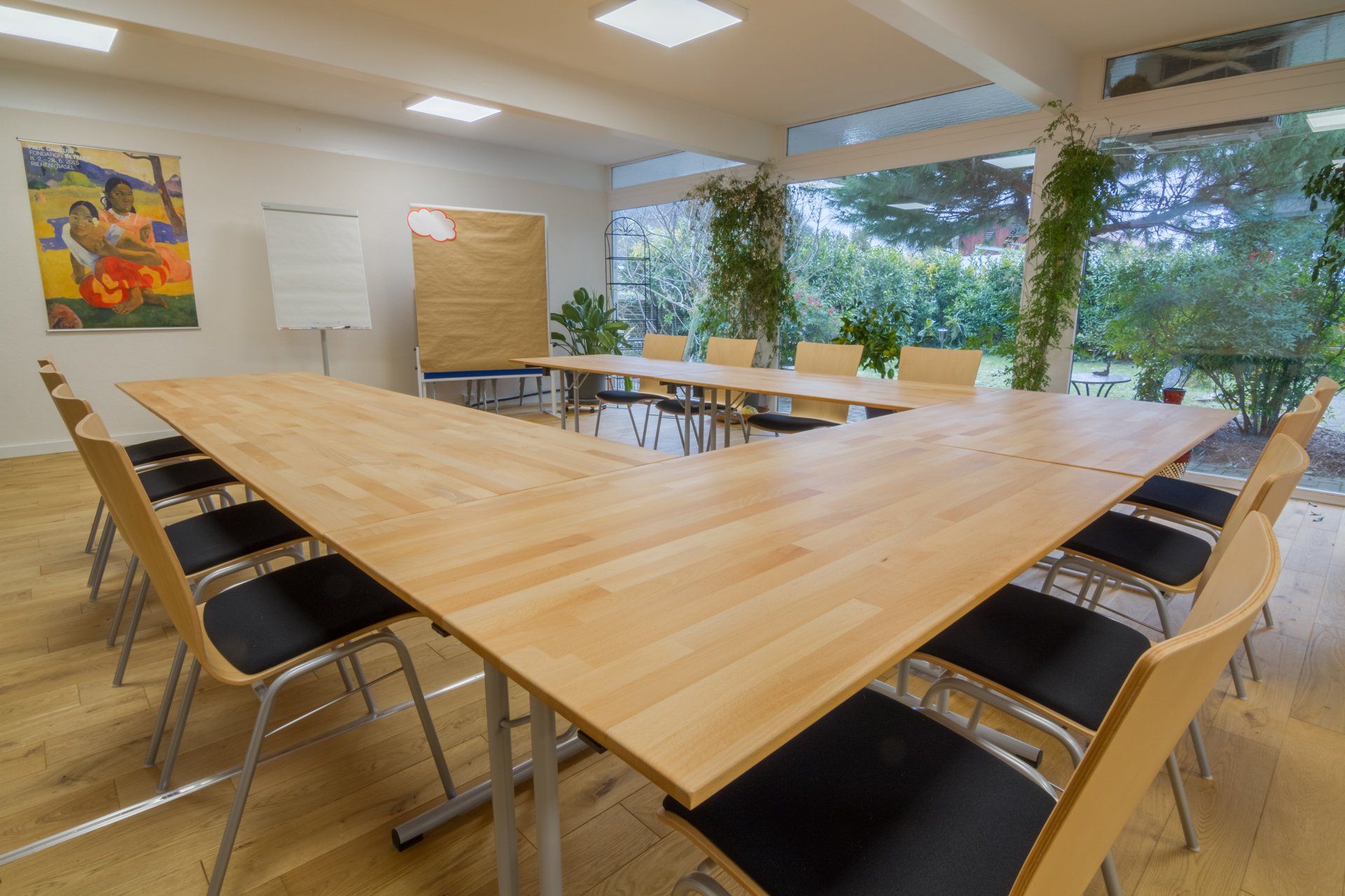 Ein Konferenzraum mit einem langen Holztisch und Stühlen.