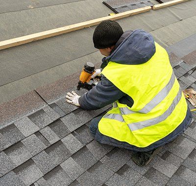 Shingles — Worker Installing Roof Shingles in Muskegon, MI Shingles — Worker Installing Roof Shingles in Muskegon, MI