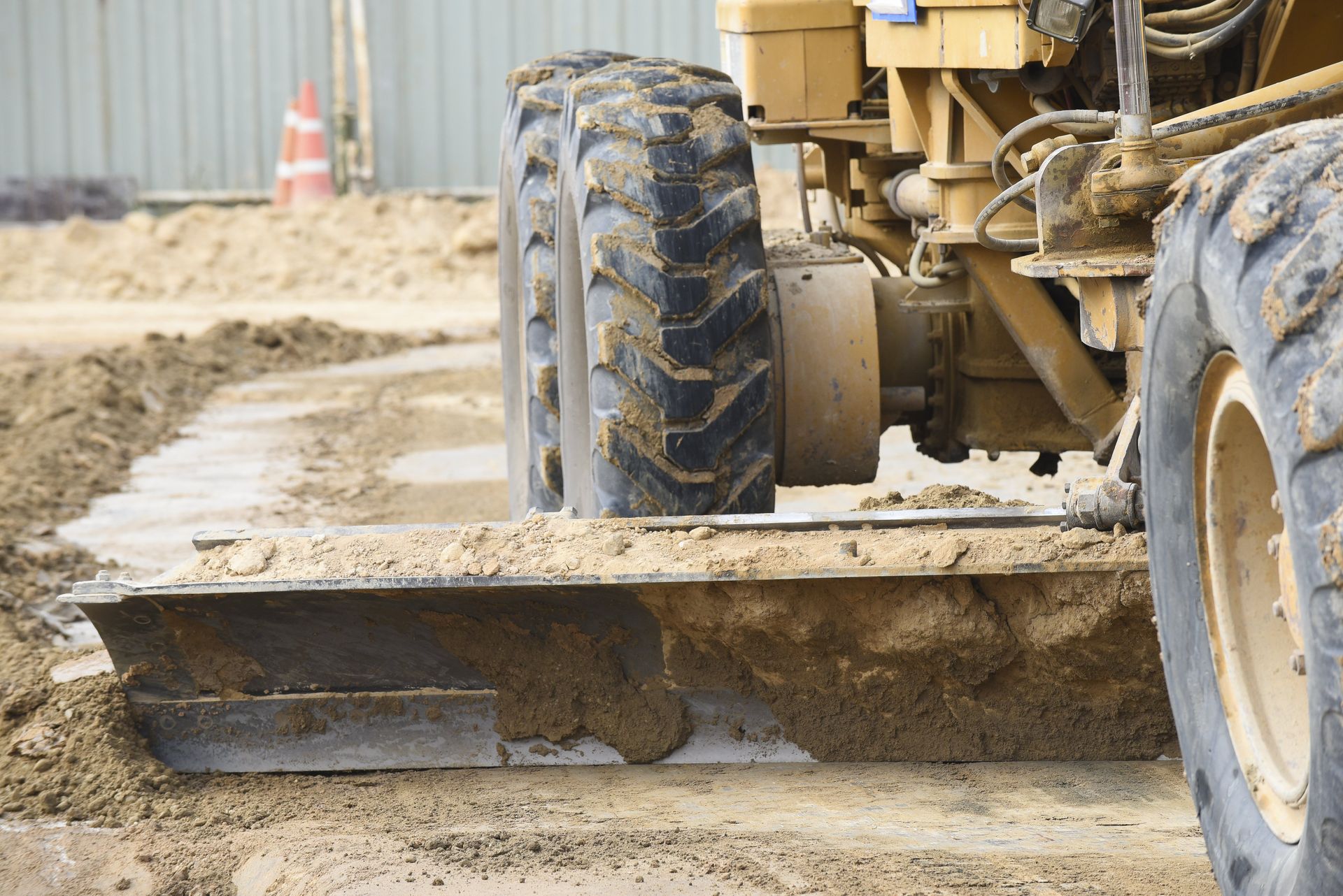 Schwere Maschinen ebnen Sand auf einer Baustelle.