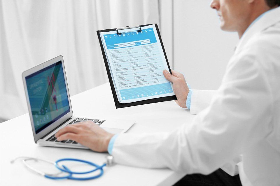 Urologo consulta la cartella clinica din un paziente