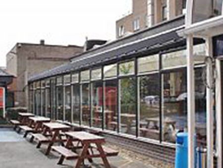 Glass fronted cafe with tables on a terrace in front