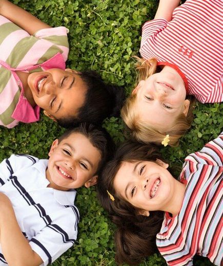 Group of Kindergarten Kids Lying on the Grass — Child Care in Rock Island, IL Group of Kindergarten Kids Lying on the Grass — Child Care in Rock Island, IL