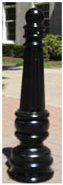 A black pole is sitting on a brick sidewalk in front of a building.
