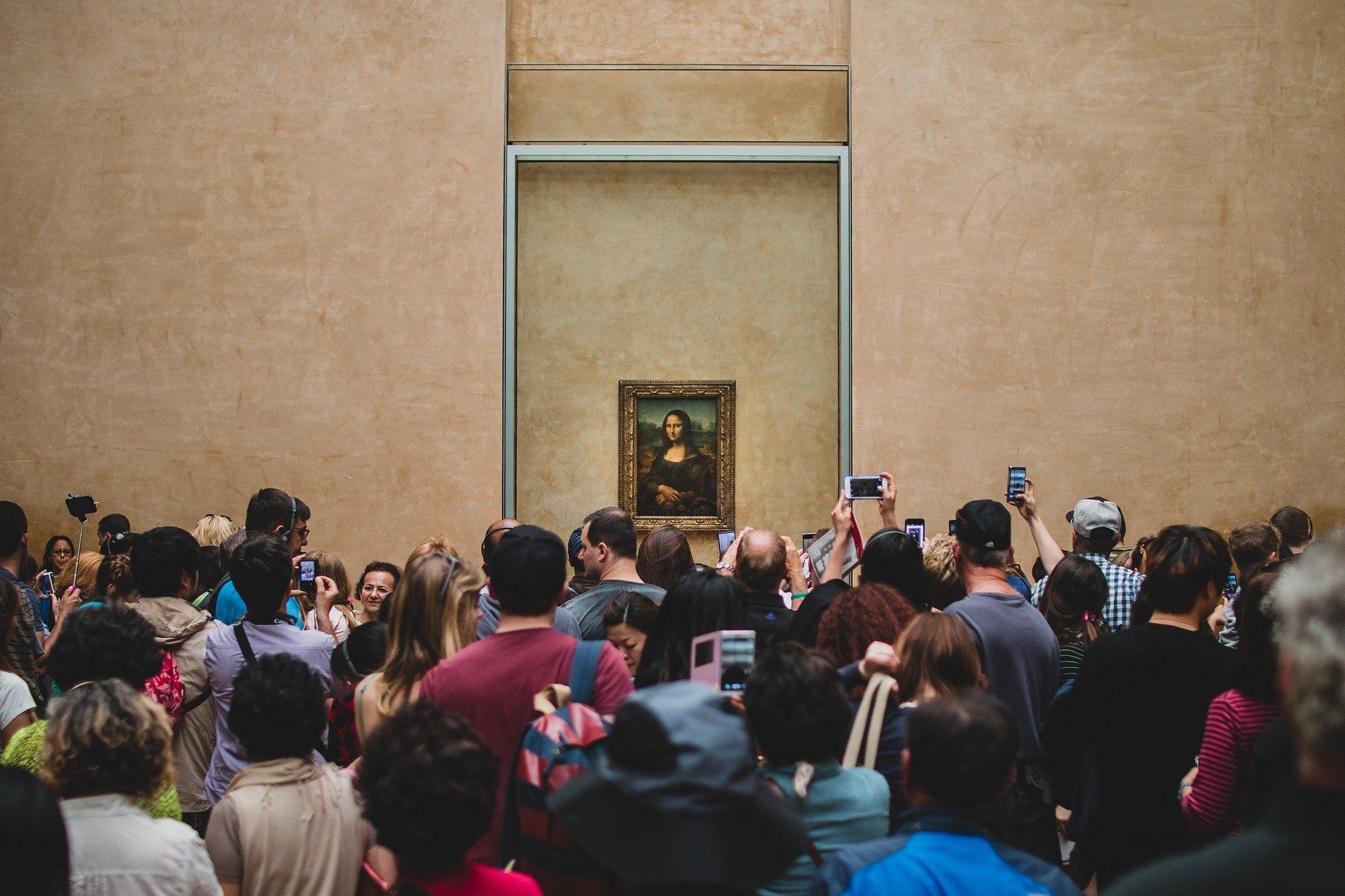 Een grote groep mensen verdringt zich bij de Mona Lisa in het Louvre om een foto te kunnen nemen van het schilderij – iets waar bij het Stay At Home Museum geen sprake van was.