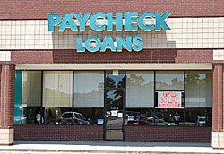 Paycheck Loans storefront with sign, brick facade, and large windows.