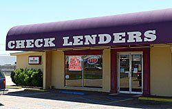 Check Lenders storefront with purple awning, beige walls, glass windows, and 