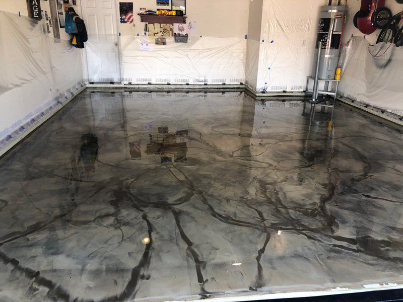 Garage with a glossy, metallic epoxy floor in shades of gray and black, reflecting the space.