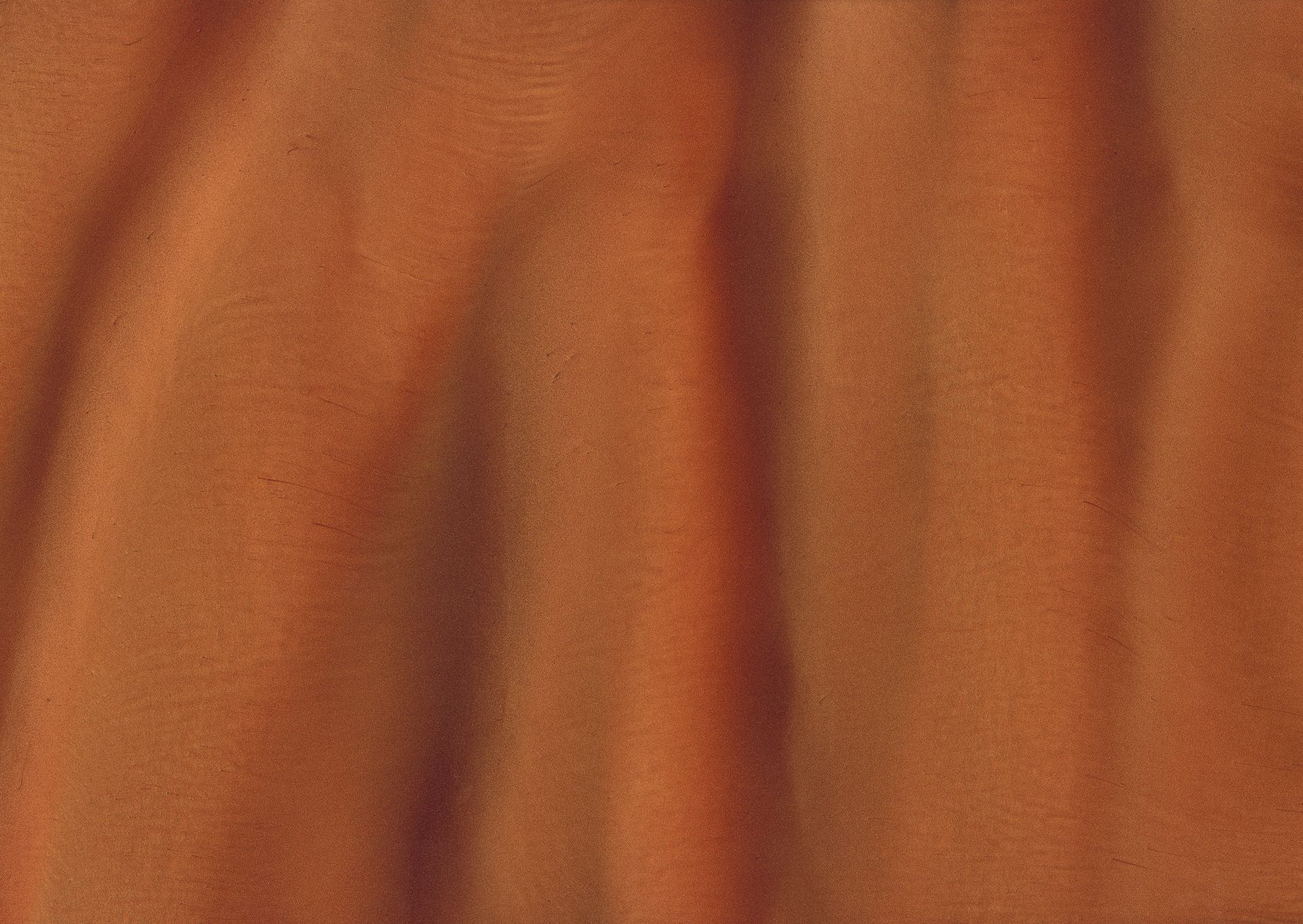 Orange-brown fabric with vertical folds creating shadows and highlights, suggesting movement or texture.