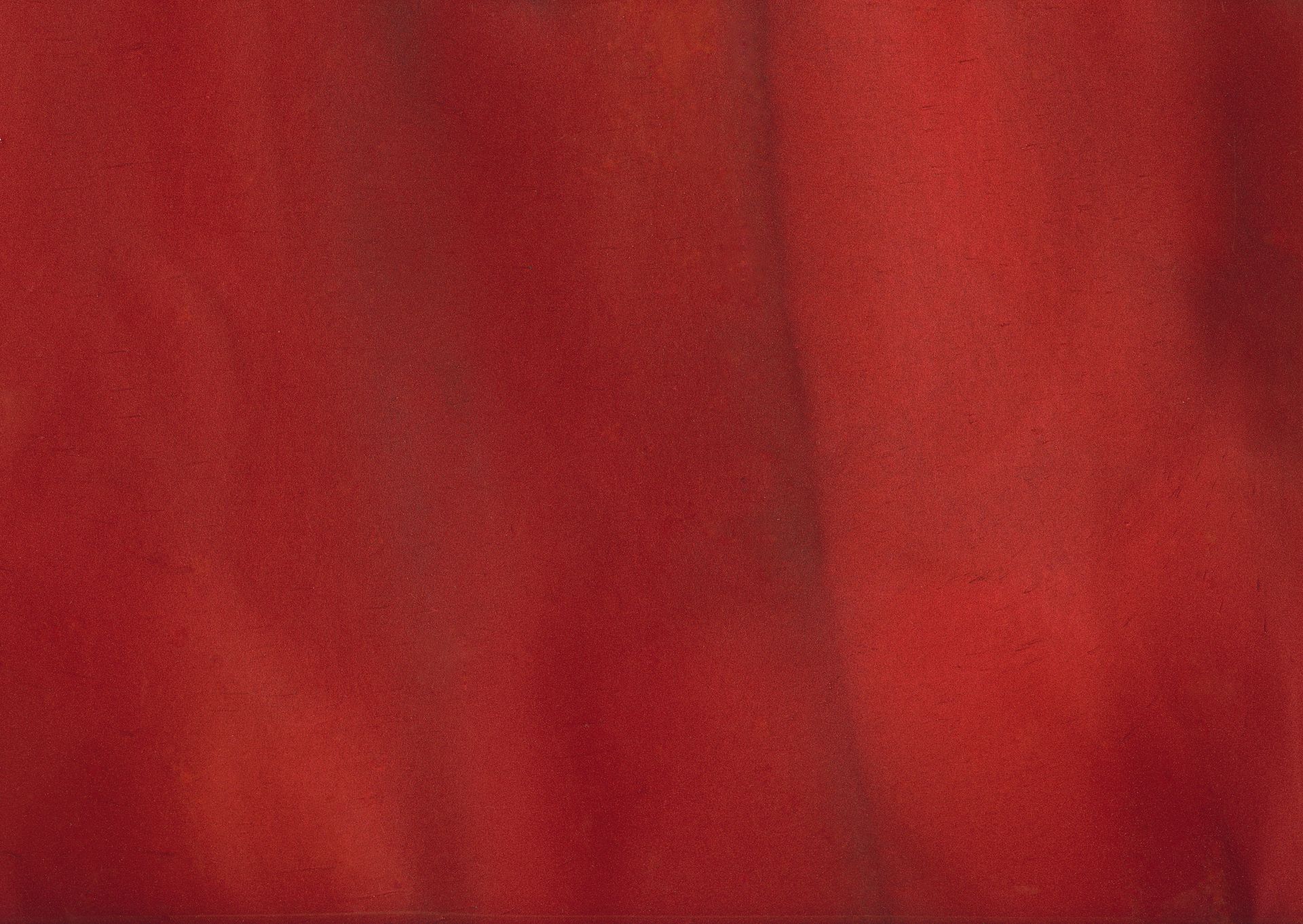 Close-up of red fabric with slight shadowing, suggesting folds and texture.
