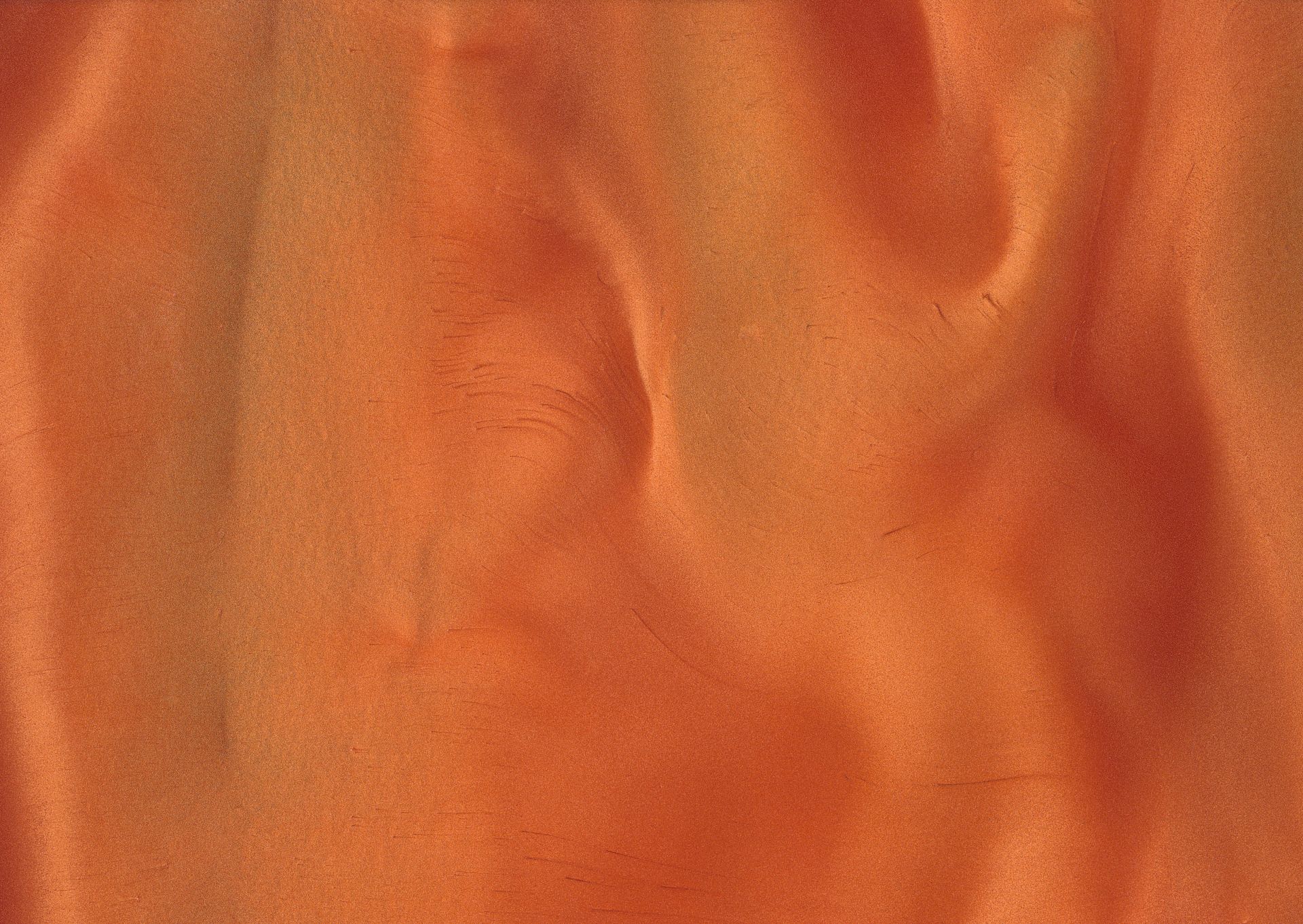Orange and yellow abstract fabric with a rippled texture and shaded patterns.