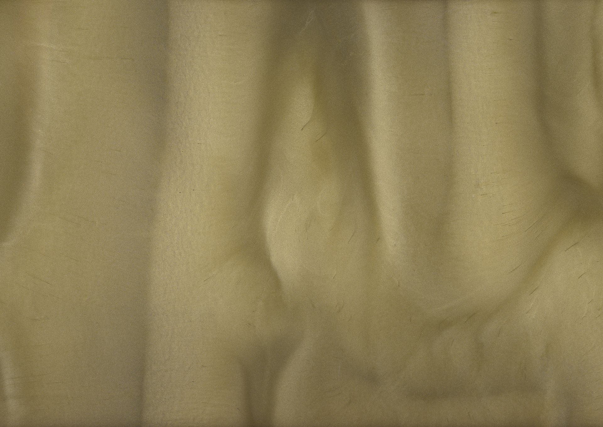 Close-up of light yellow fabric with soft, flowing folds and shadows, creating a textured appearance.