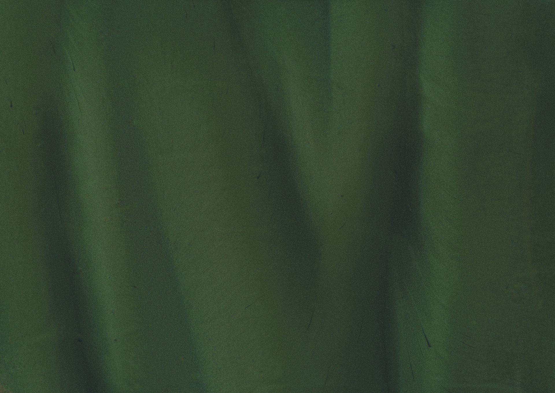Green fabric with wavy folds, creating shadows and highlights.