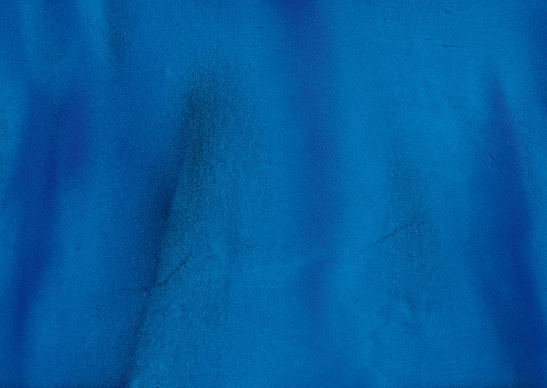 Close-up of vibrant blue fabric with subtle texture and folds.