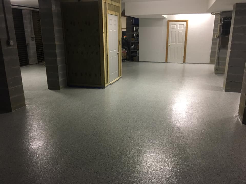 A spacious, polished gray-painted concrete floor in a basement-like storage area with storage units, concrete .