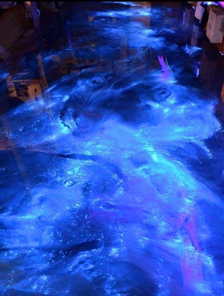 Glowing blue and purple epoxy floor, resembling a flowing river or nebula.