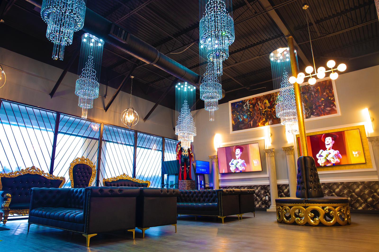Elegant lounge interior with blue crystal chandeliers, dark seating, and glowing framed wall screens