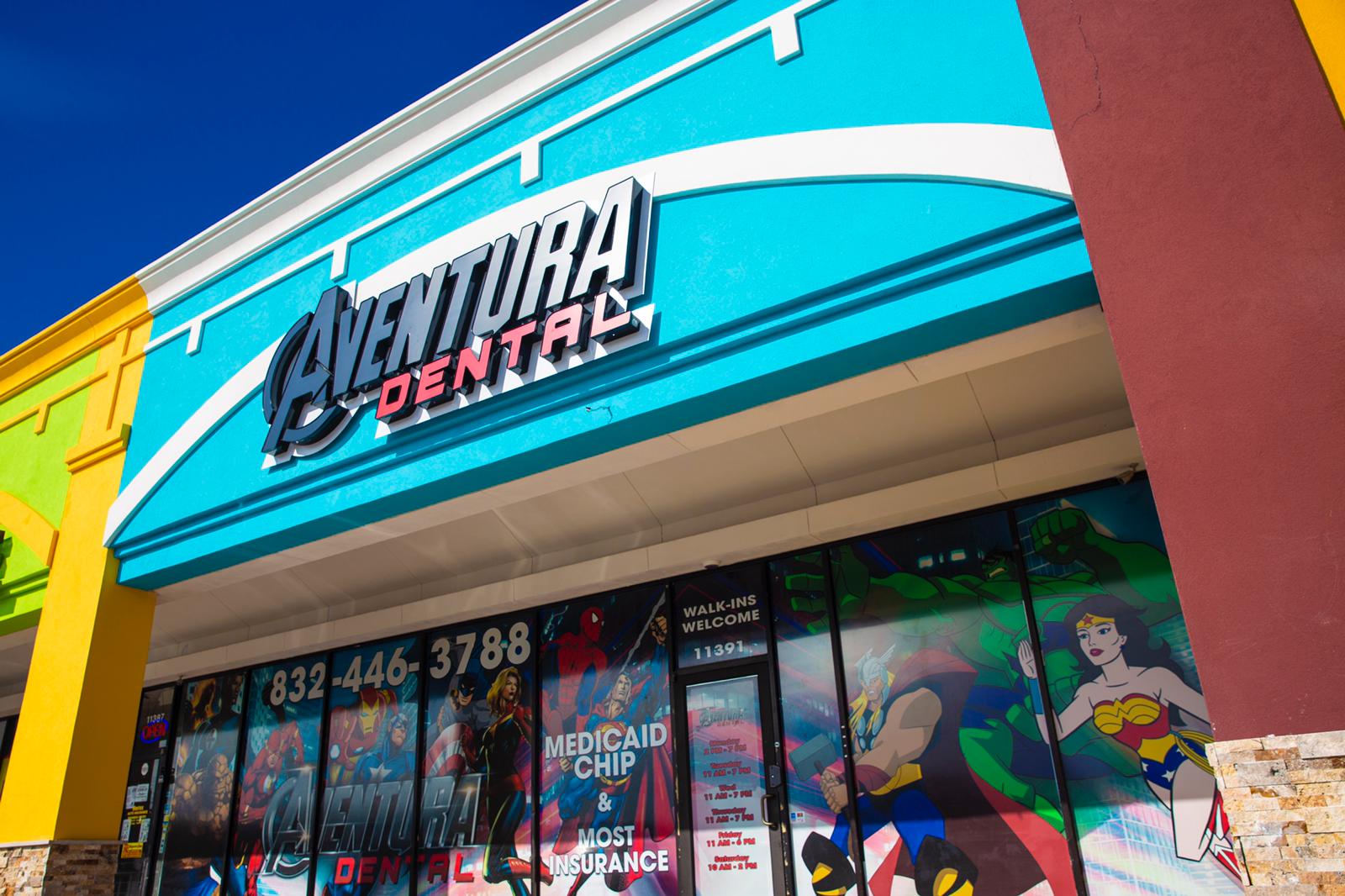 Adventure Dental storefront with turquoise sign and colorful window graphics