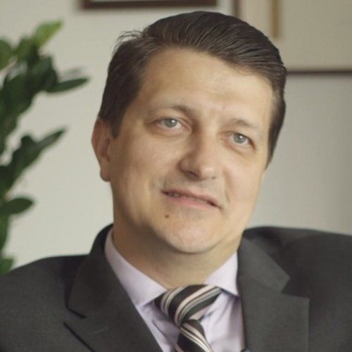 A man in a suit and tie smiles for the camera