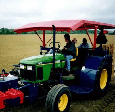 A john deere tractor with a red canopy on top of it
