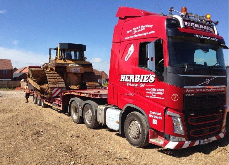 Haulage vehicle carrying heavy machinery on road