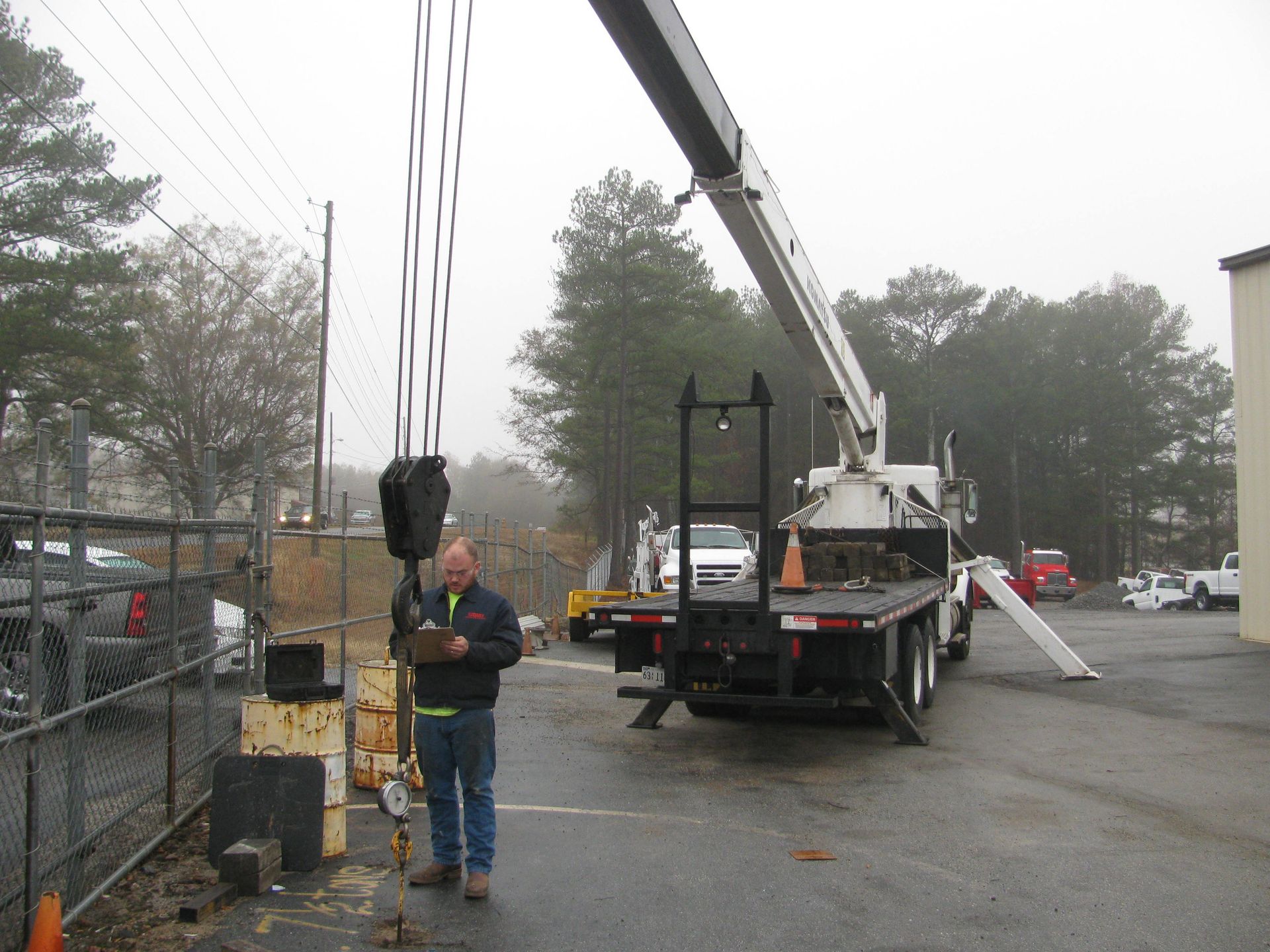 A man stands in front of a crane in a parking lot