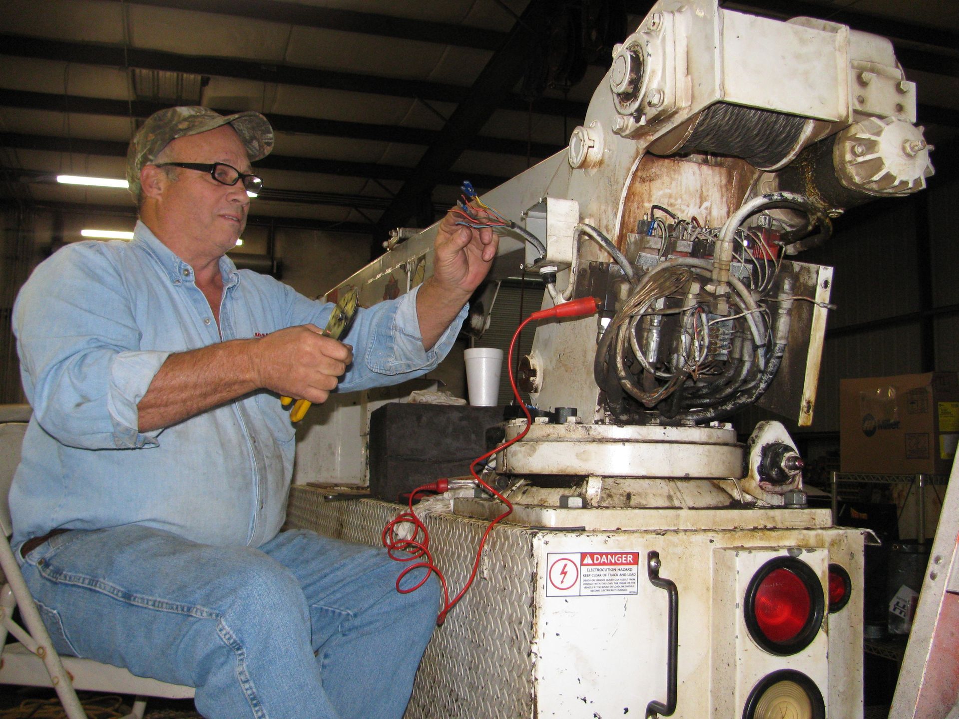 A man is working on a machine that has a warning sign on it