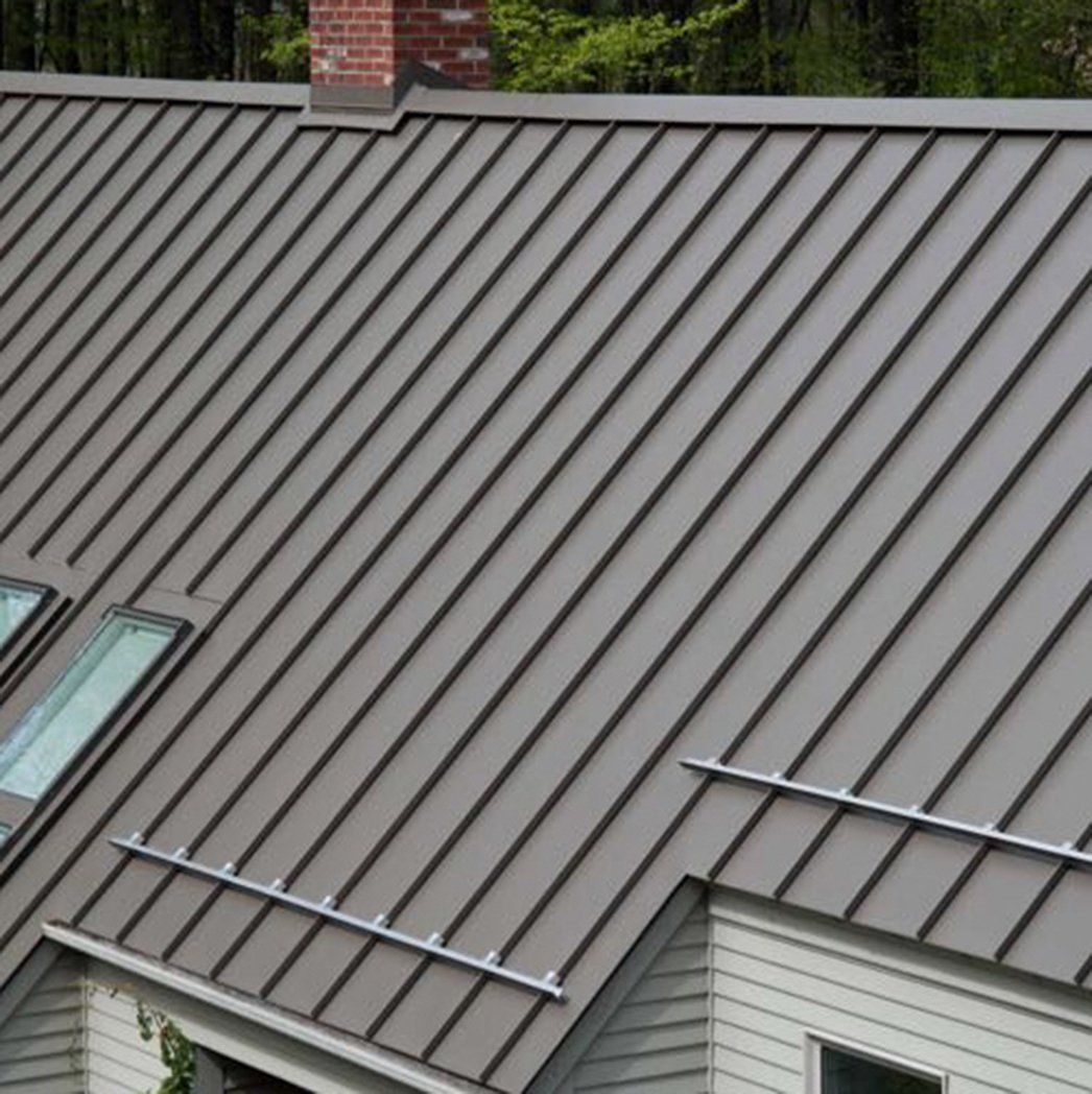 A close up of a metal roof on a house with a skylight.