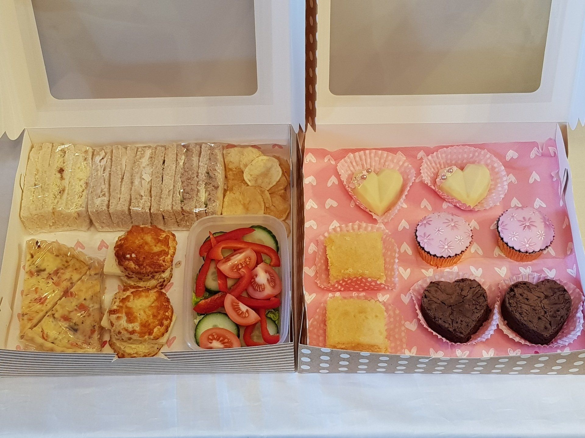 Two boxes of food are sitting next to each other on a table.