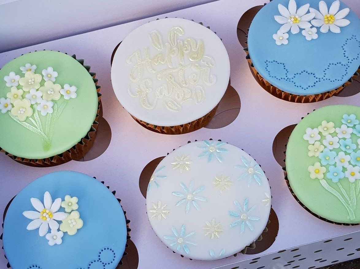A box of cupcakes with flowers on them