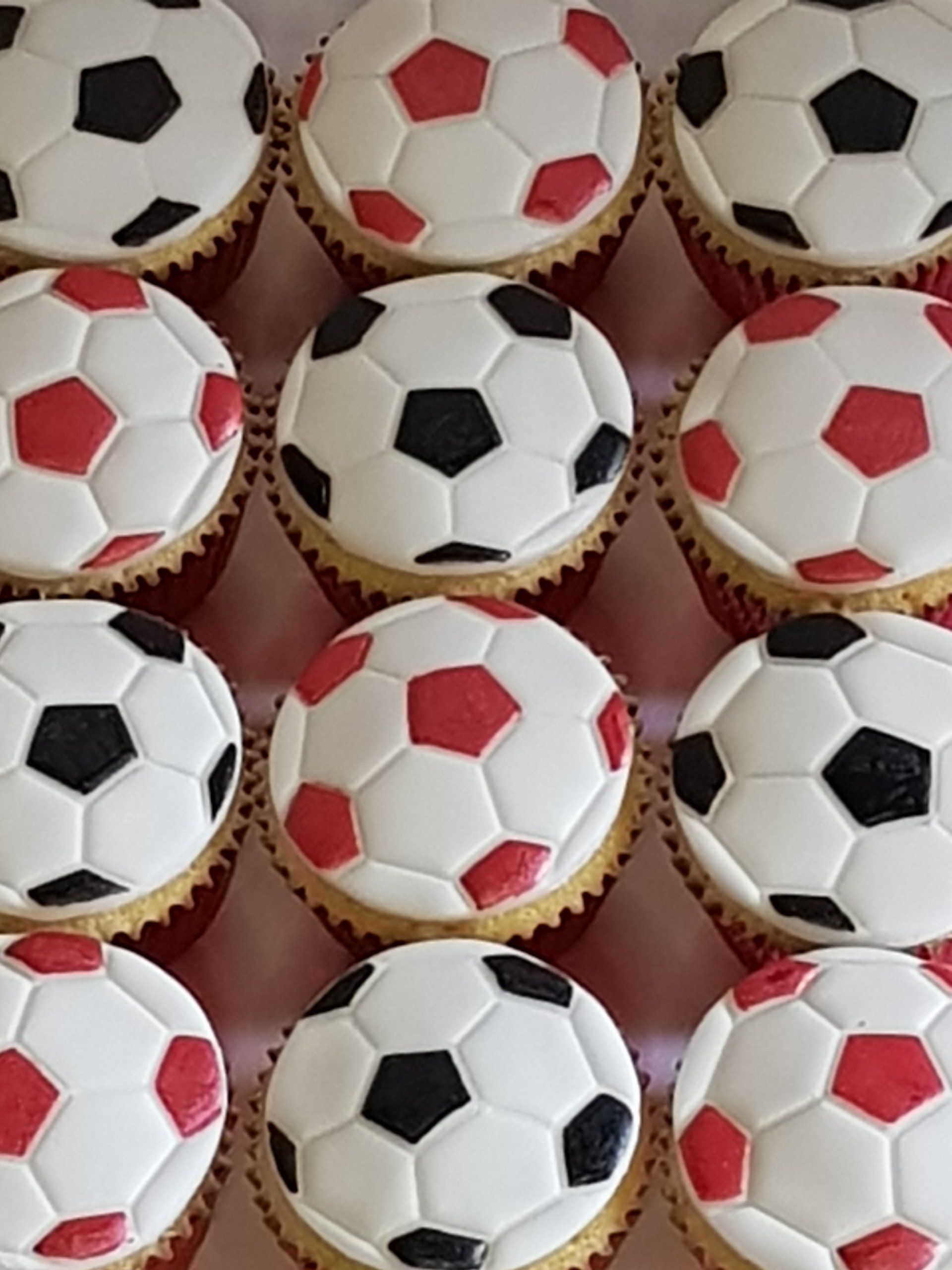 A bunch of cupcakes with soccer balls on them