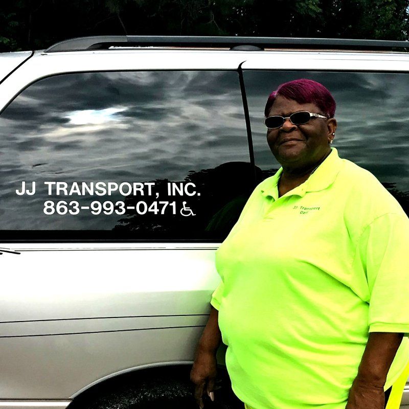 woman professional standing next to J J Transport of Arcadia Inc  car