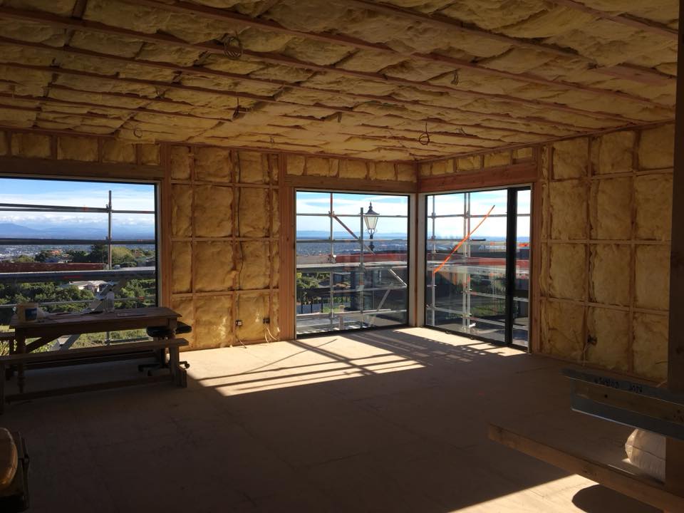A room with a lot of windows and insulation on the walls.