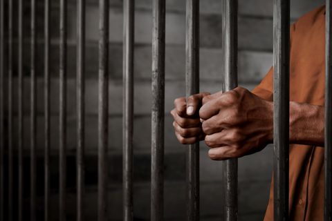 Man Holding on Prison Bars — Fort Pierce, FL — A Johnson Bail Bonds Man Holding on Prison Bars — Fort Pierce, FL — A Johnson Bail Bonds