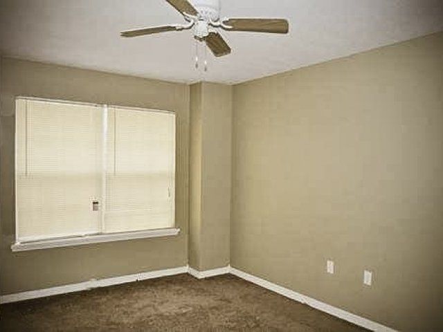 Bedroom with ceiling fan and large window