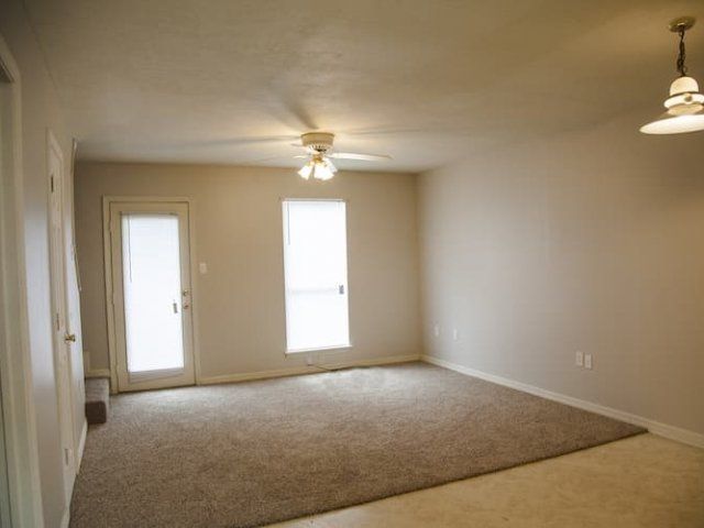 Carpeted living room with ceiling fan