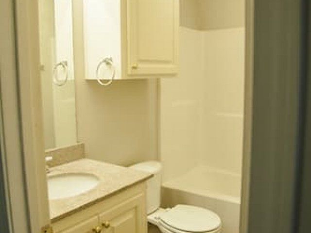 Full bathroom with small vanity and cabinet above toilet