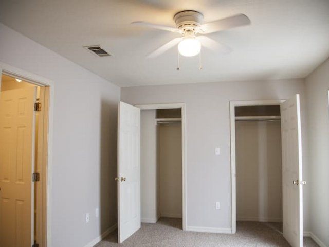 Bedroom with ceiling fans and double closets