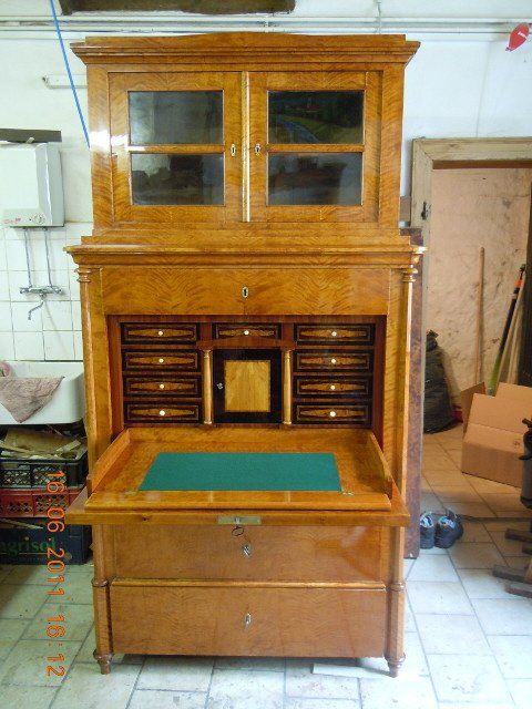 Sekretär aus Holz mit Aufsatzschrank und Schubladen aus Glas, der in einem gefliesten Raum steht.